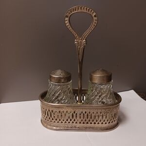 Vintage salt and pepper shakers in metal carrier. Glass shakers with metal lids.